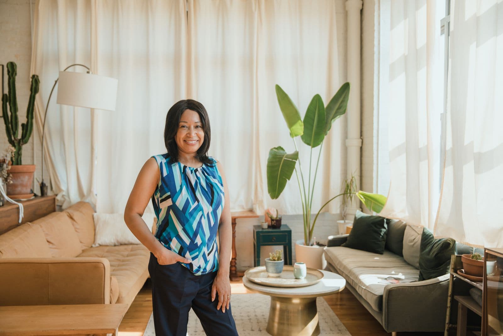 Woman smiling confidently in the sunlit living room of her home